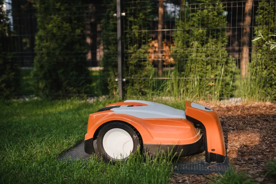 Robot tondeuse autonome sur base de recharge dans un jardin